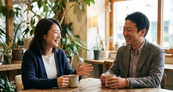 カフェのテーブルで向かい合って話す男女