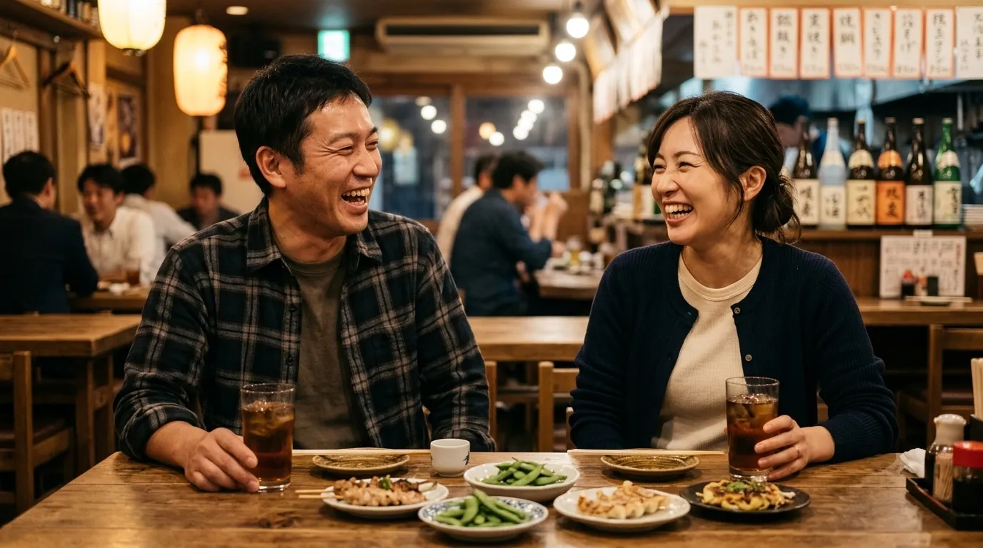 居酒屋で食事をしながら打ち解けて笑う男女